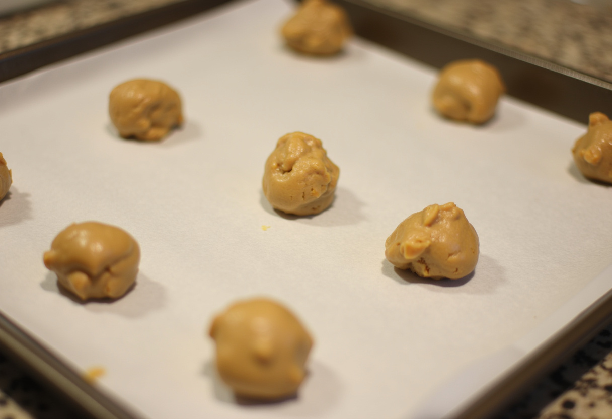 Cookie dough scoops on a baking sheet for Cookies and Cream Cookies.