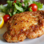 Crispy air-fried chicken breast with salad and lemon, ready to serve.